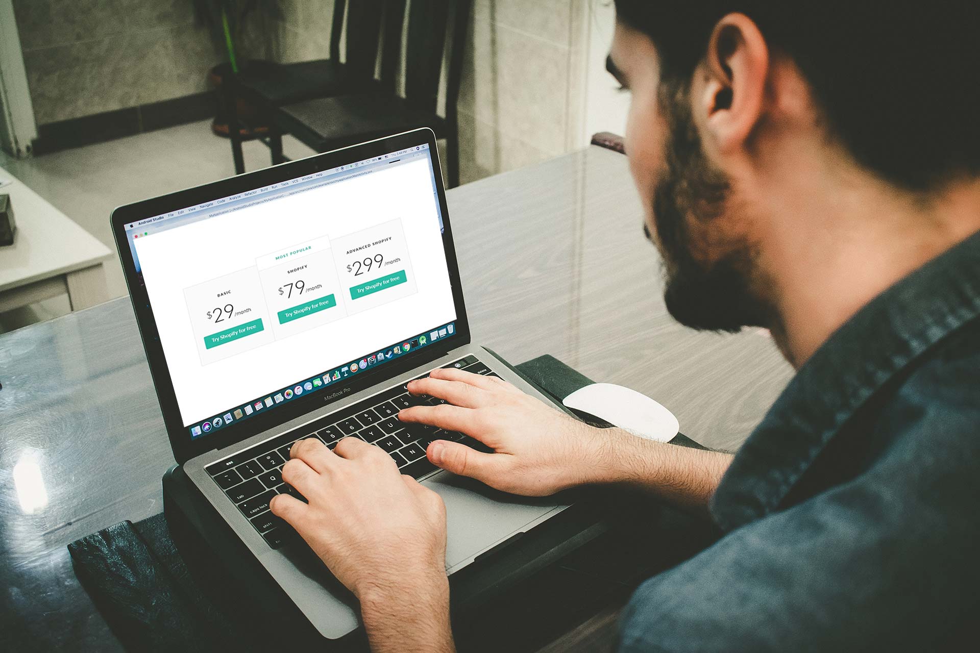 άντρας σε λάπτοπ βλέπει Shopify κόστος