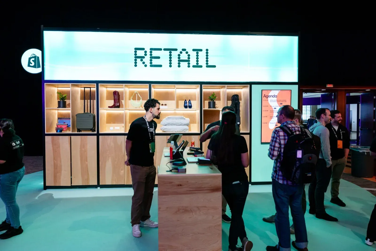 Booth Retail με φωτισμένα ράφια προϊόντων και επισκέπτες στον πάγκο