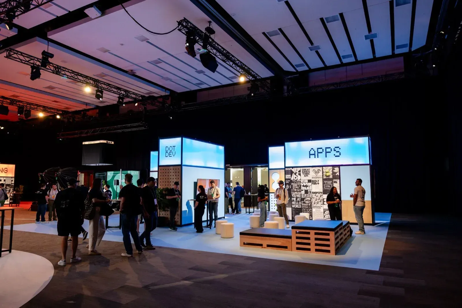 Booth Apps στο expo floor του DotDev με επισκέπτες κάτω από τον φωτισμό σκηνής