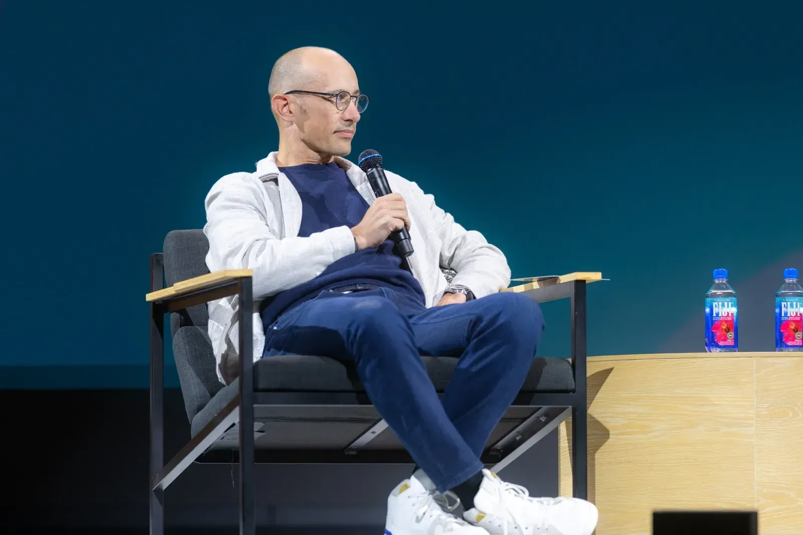 Ο Tobi Lütke καθισμένος με μικρόφωνο στη σκηνή του fireside chat