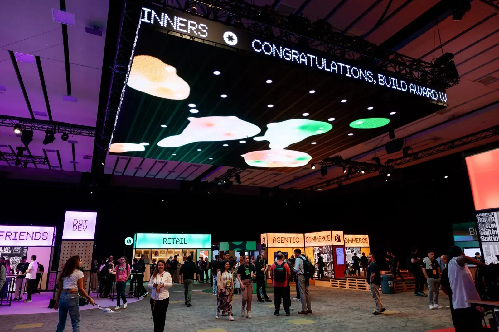 Ευρεία άποψη του expo hall με τεράστια LED οροφή που δείχνει συγχαρητήρια στους νικητές