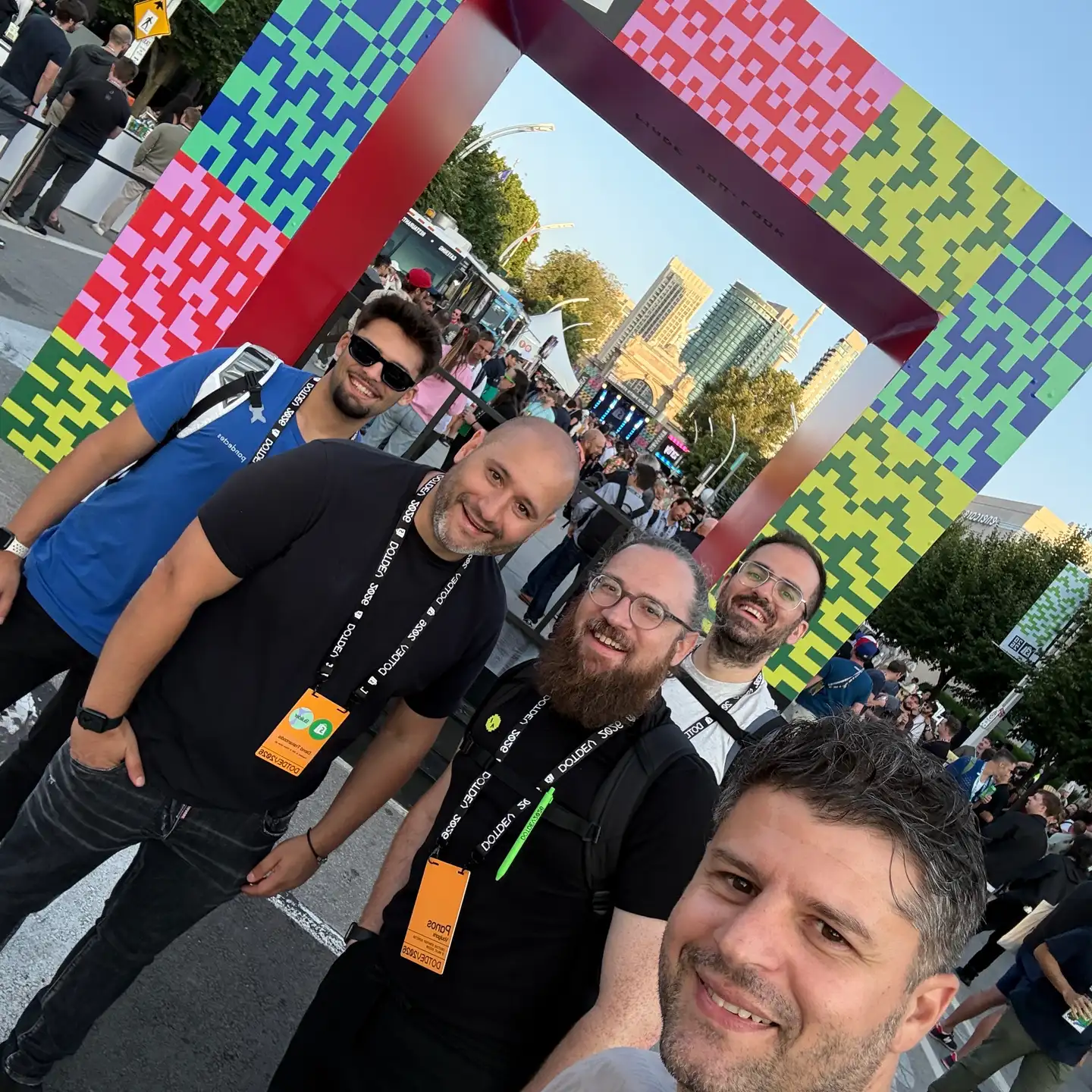 Η ομάδα της Think Plus βγάζει selfie στο Block Party του DotDev μπροστά σε πολύχρωμο πλαίσιο